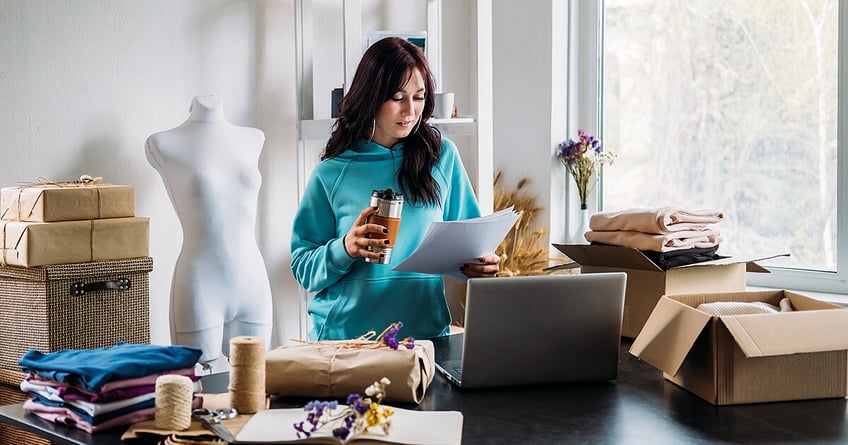 Woman starting an online shop looking at a paper