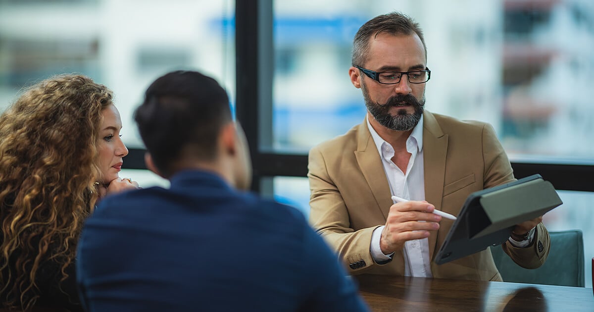 Business owners discussing grant application together around board room table