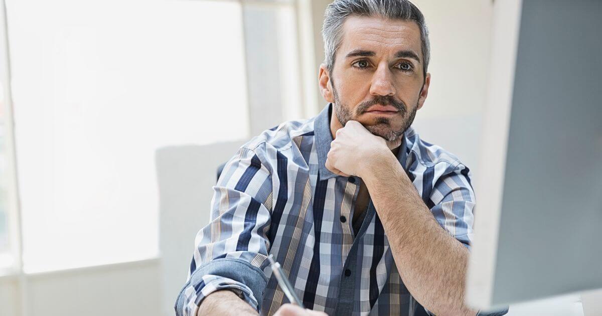 man looking at computer getting ready to write a blog