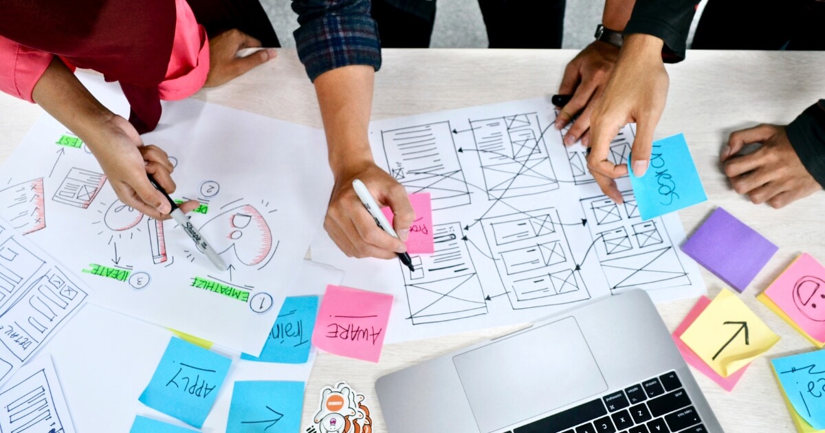 Designing a website's architecture with sticky notes and paper