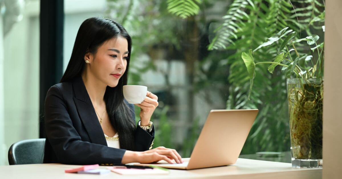 Women drinking coffee and using laptop to learn about email marketing campaigns