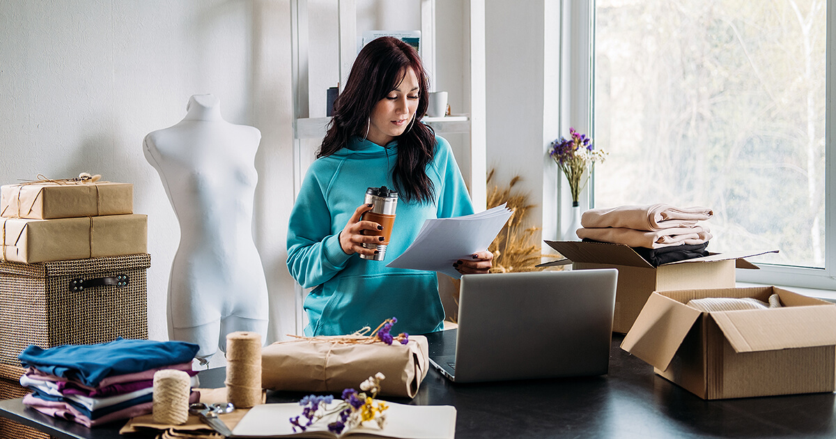 Woman starting an online shop looking at a paper