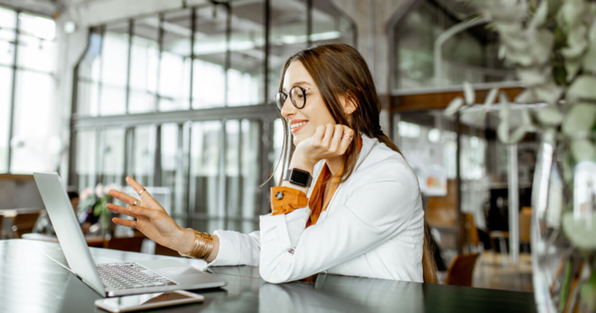 A woman sitting at a desk on her computer